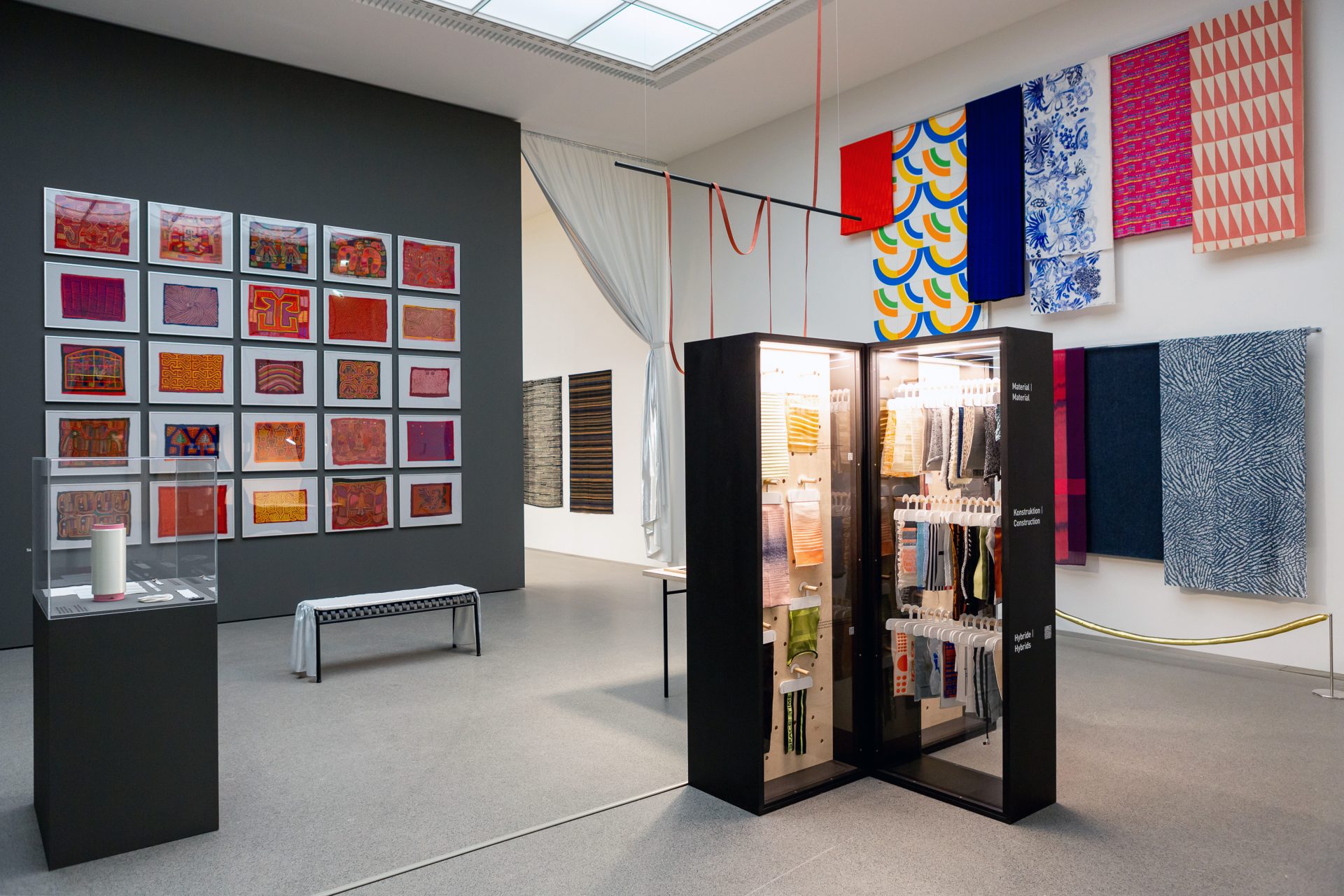 Wall with textiles in frames and hanging textiles, architecure with textile samples
