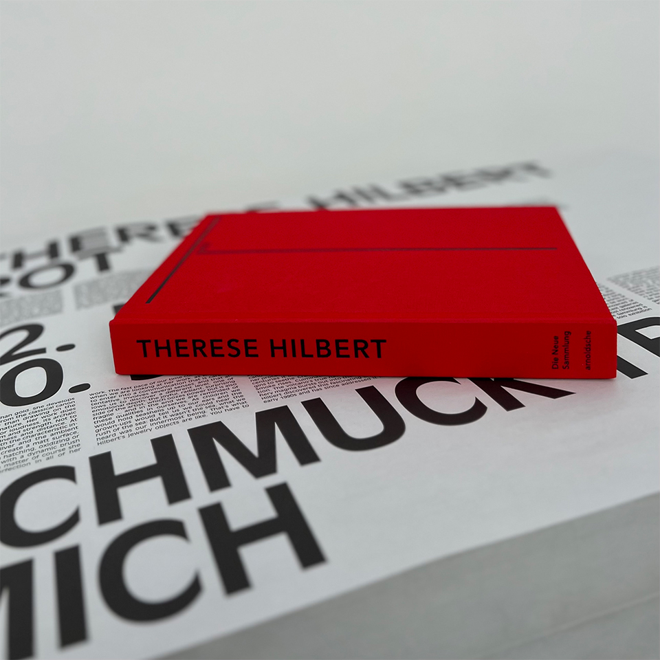 Ausstellungskatalog mit rotem Einband, Beschriftung, schwarze Buchstaben. Buchdeckel Anfangsbuchstabe des Vornamens T ROT, Buchrückseite Anfangsbuchstabe des Nachnamens H Red, Buchrücken, THERESE HILBERT