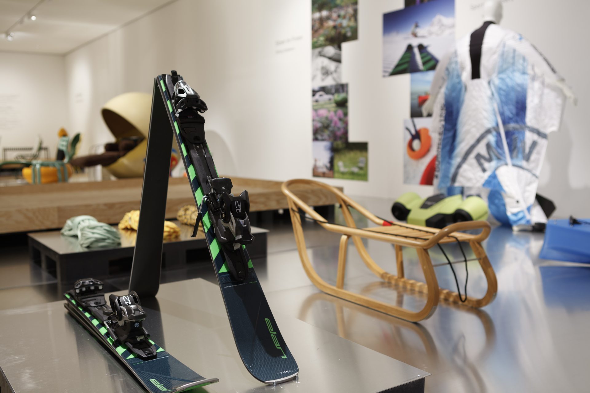 In the foreground an easy-to-fold ski, behind are sled, climbing ropes and a wingsuit