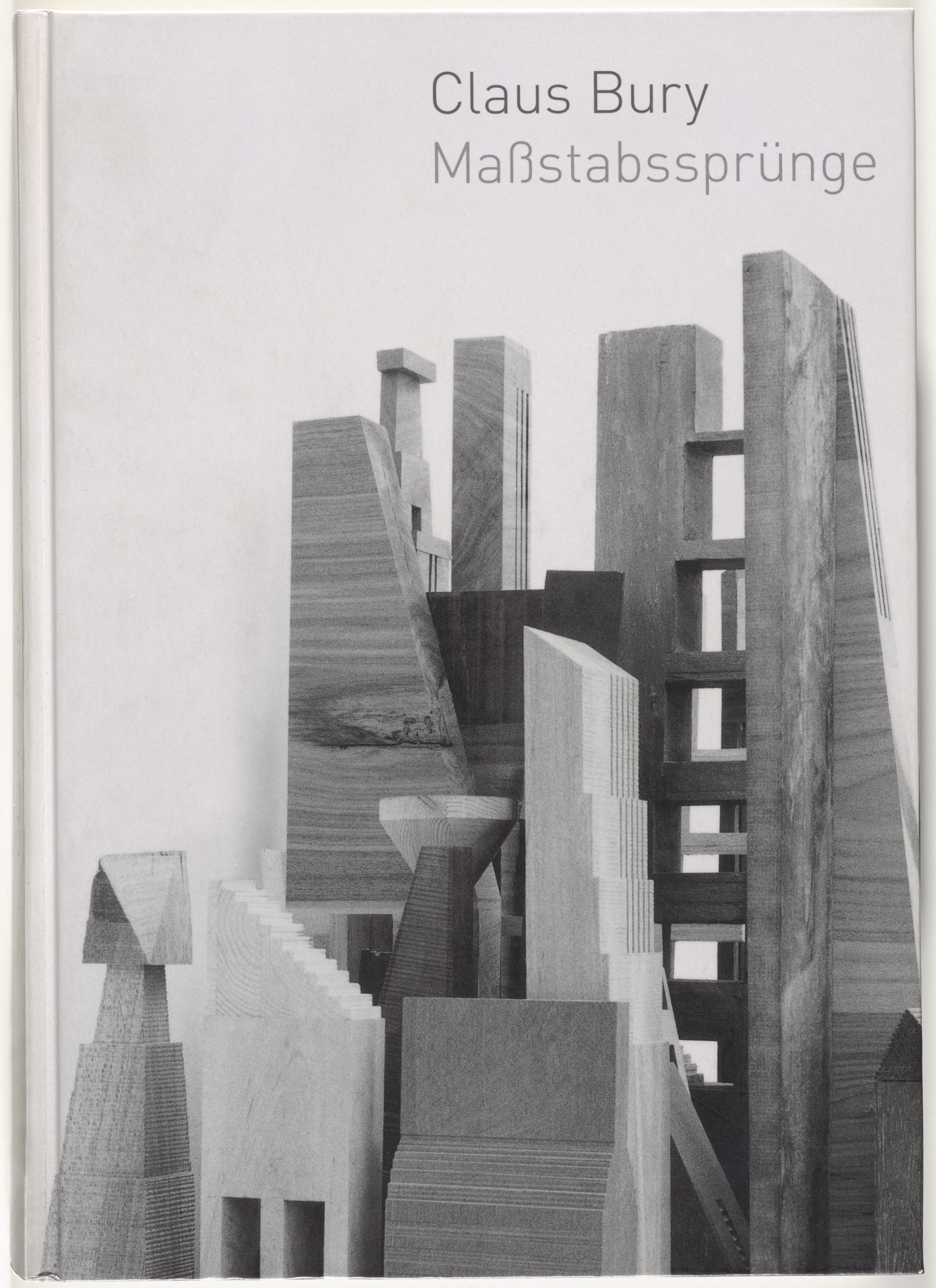 Cover exhibition catalog. It shows a black and white photograph with various wooden building elements. The arrangement is reminiscent of a cityscape. Above it is the title in the top right-hand corner.