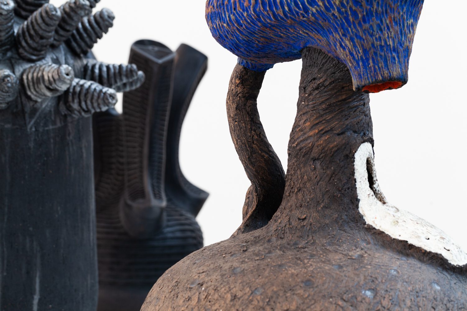 Detailed photos of three ceramic objects by artists from Africa