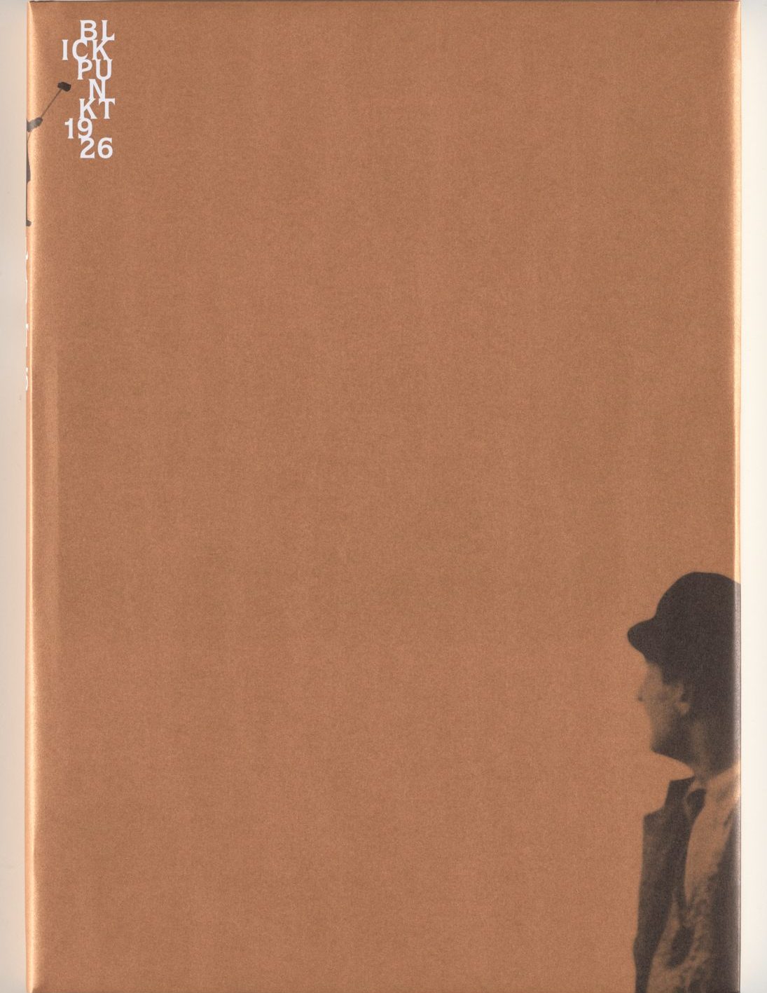 Auf bronzefarbenem Untergrund in der rechten unteren Ecke angeschnittene s/w-Fotografie des Oberkörpers eines Mannes mit Schiebermütze der nach links blickt. In der linken oberen Ecken weiße Beschriftung des getrennten Wortes: Blickpunkt 1926 (Bl-ick-pu-n-kt-19-26).