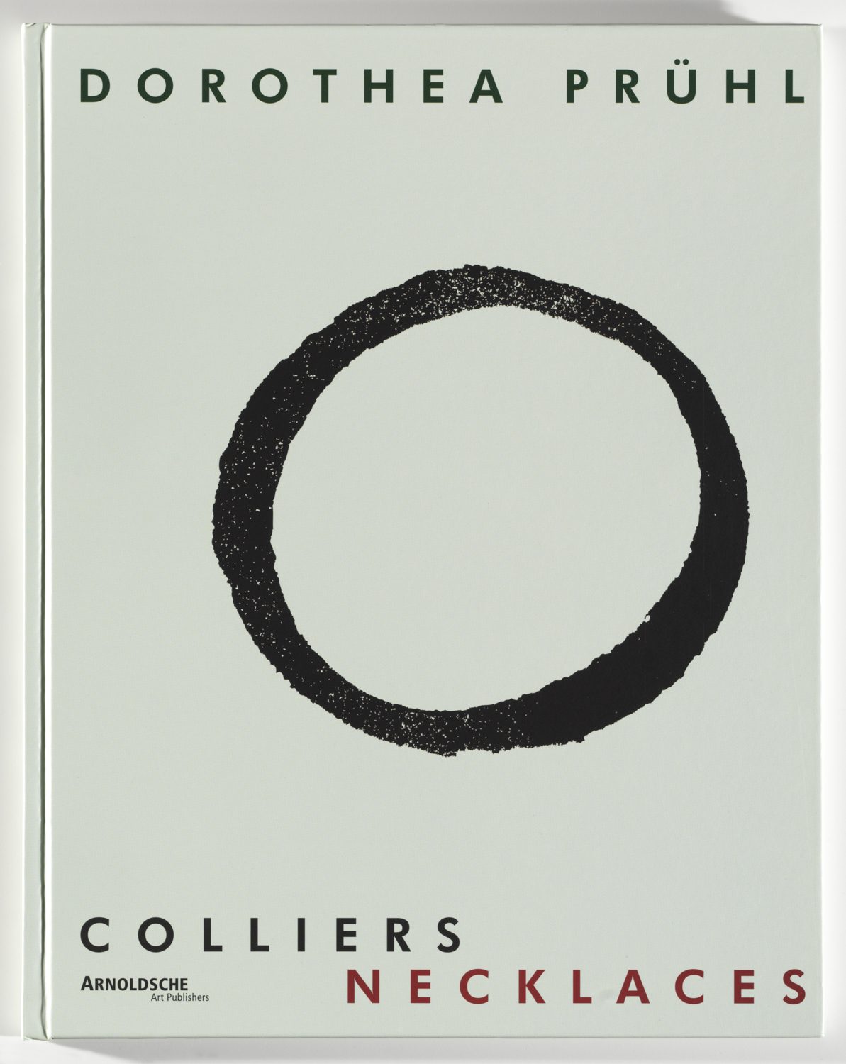 On a white background, an almost round circle slightly shifted from the centre to the right with irregular line thickness as if drawn by hand. Inscription above: Dorothea Prühl, below: Colliers Necklaces.