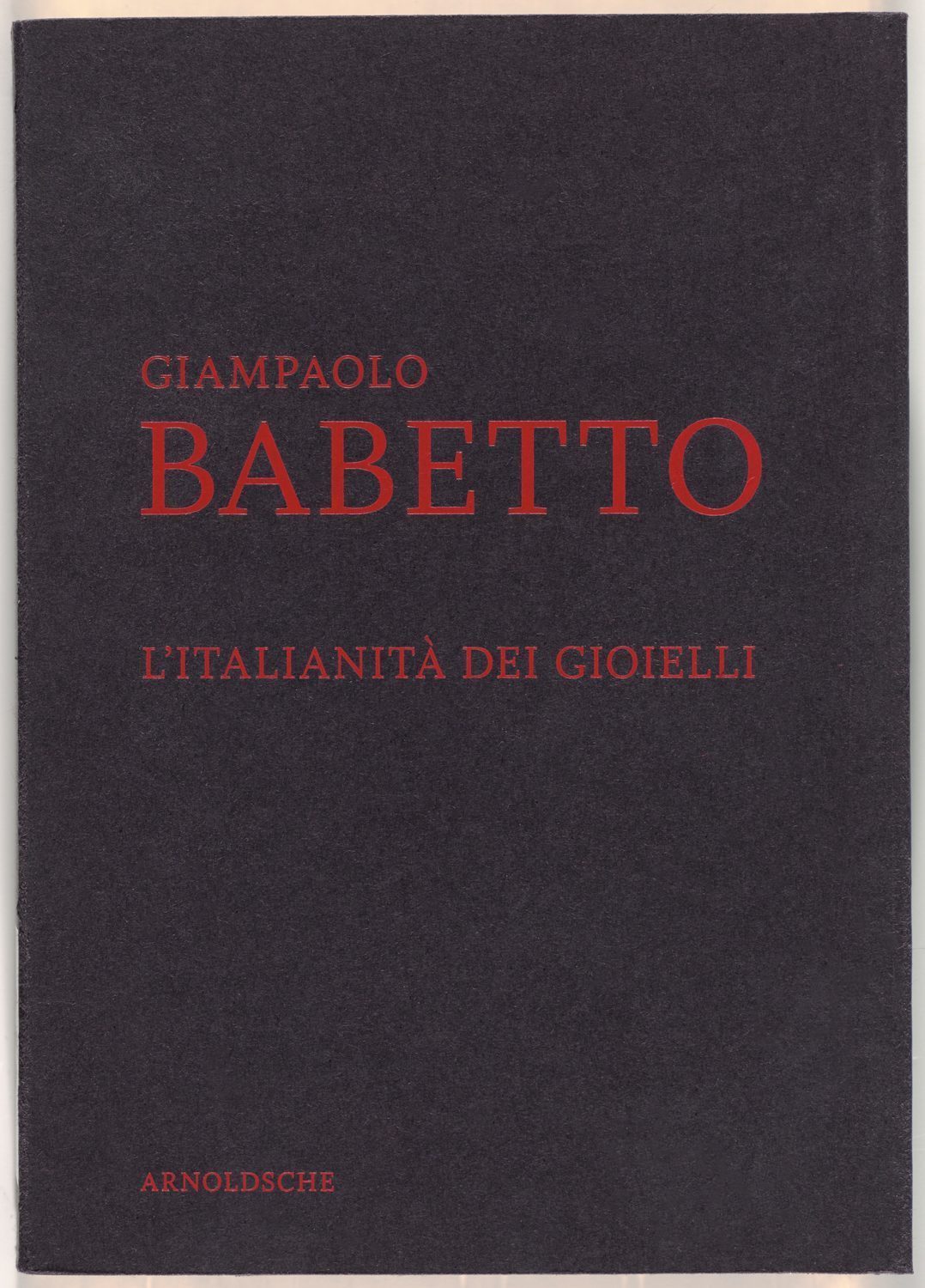 Red letters engraved on a black background: Giampaolo Babetto. L'Italianità dei Gioielli.