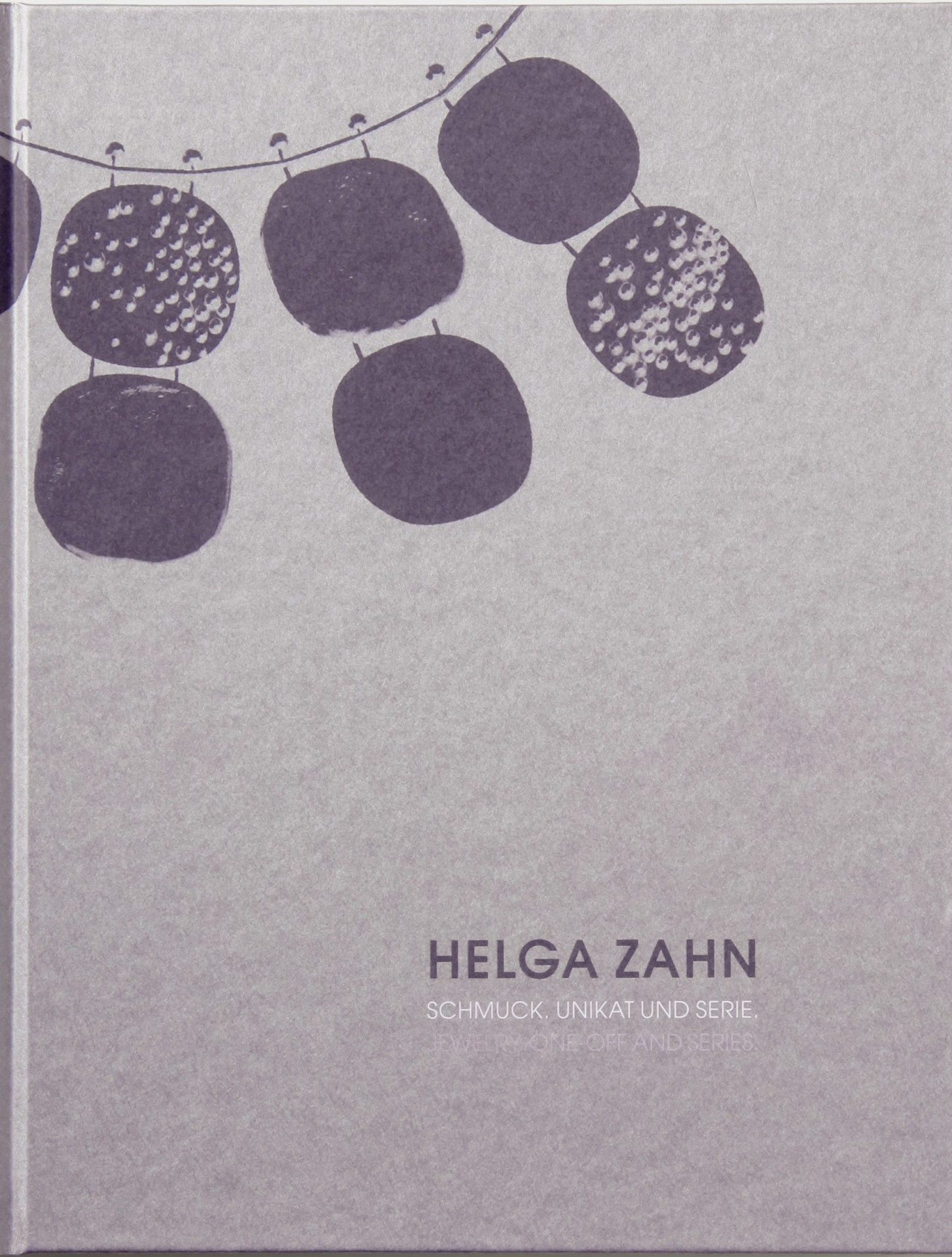 Auf hellgrauem Untergrund in linker oberer Ecke Teile eines Halsschmuckes: an einem Draht drei Elemente, die aus jeweils aus zwei mit einander verbundenen abgerundeten Rechtecken bestehen. Rechts unten Beschriftung: Helga Zahn Schmuck. Unikat und Serie.