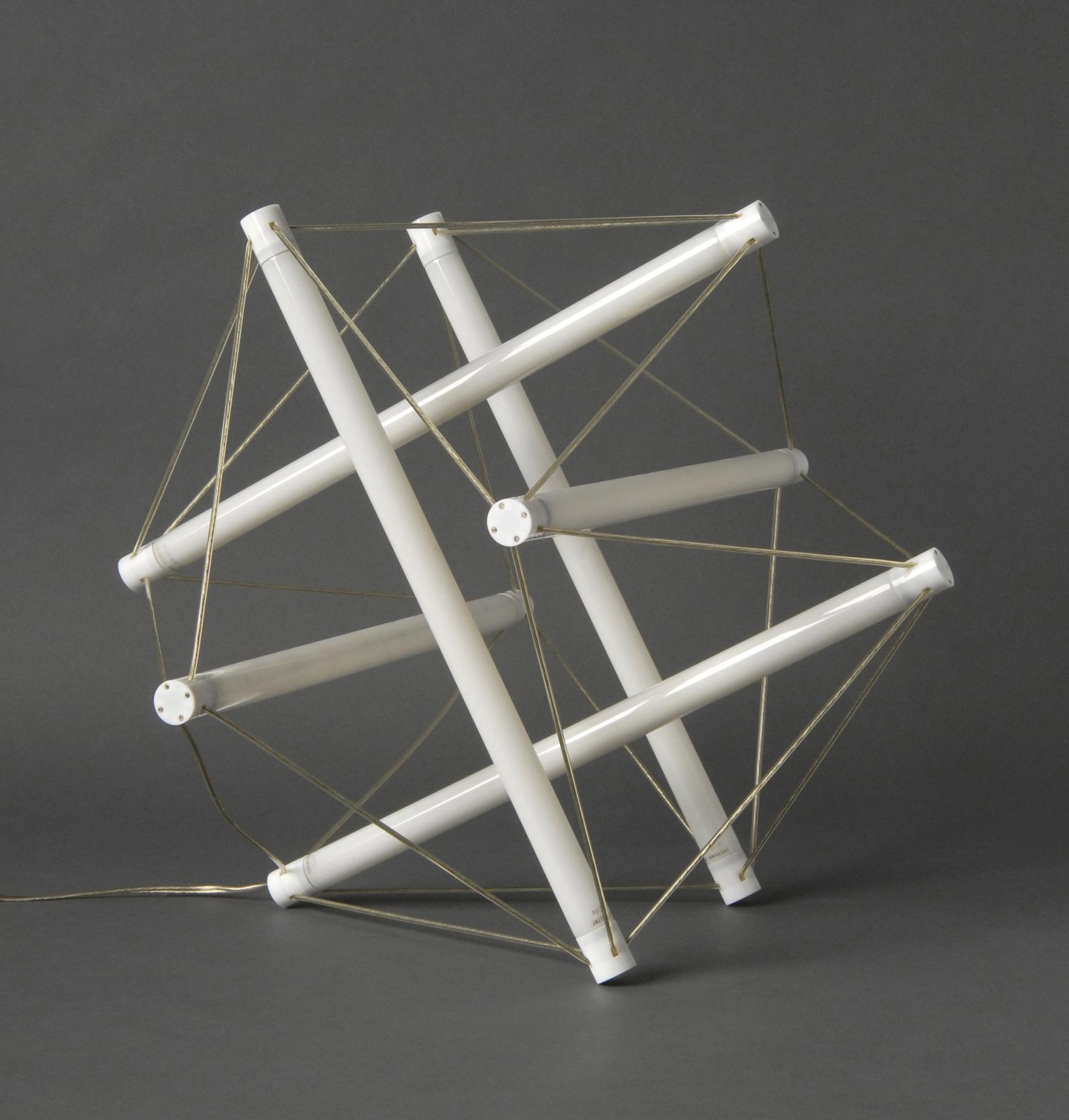 Geometric luminaire made of white tubes connected by taut cords.