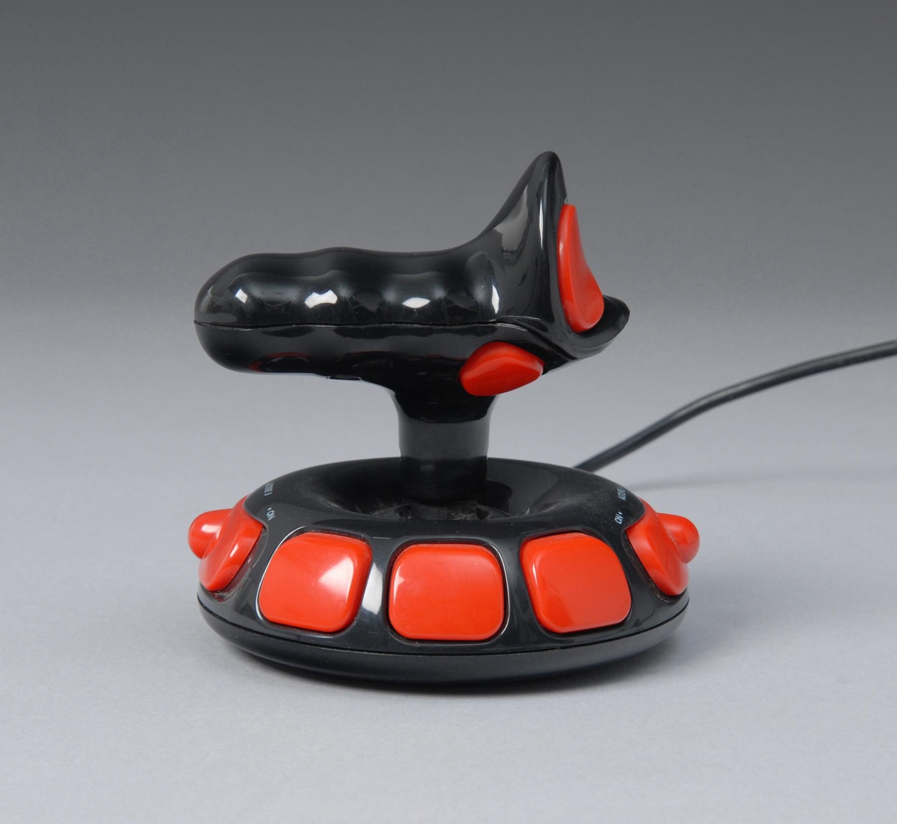 Joystick mit ergonomischem Griff in Schwarz und Rot. Die Basis ist mit mehreren großen, roten Tasten umrandet, und der Griff verfügt über zusätzliche Tasten.