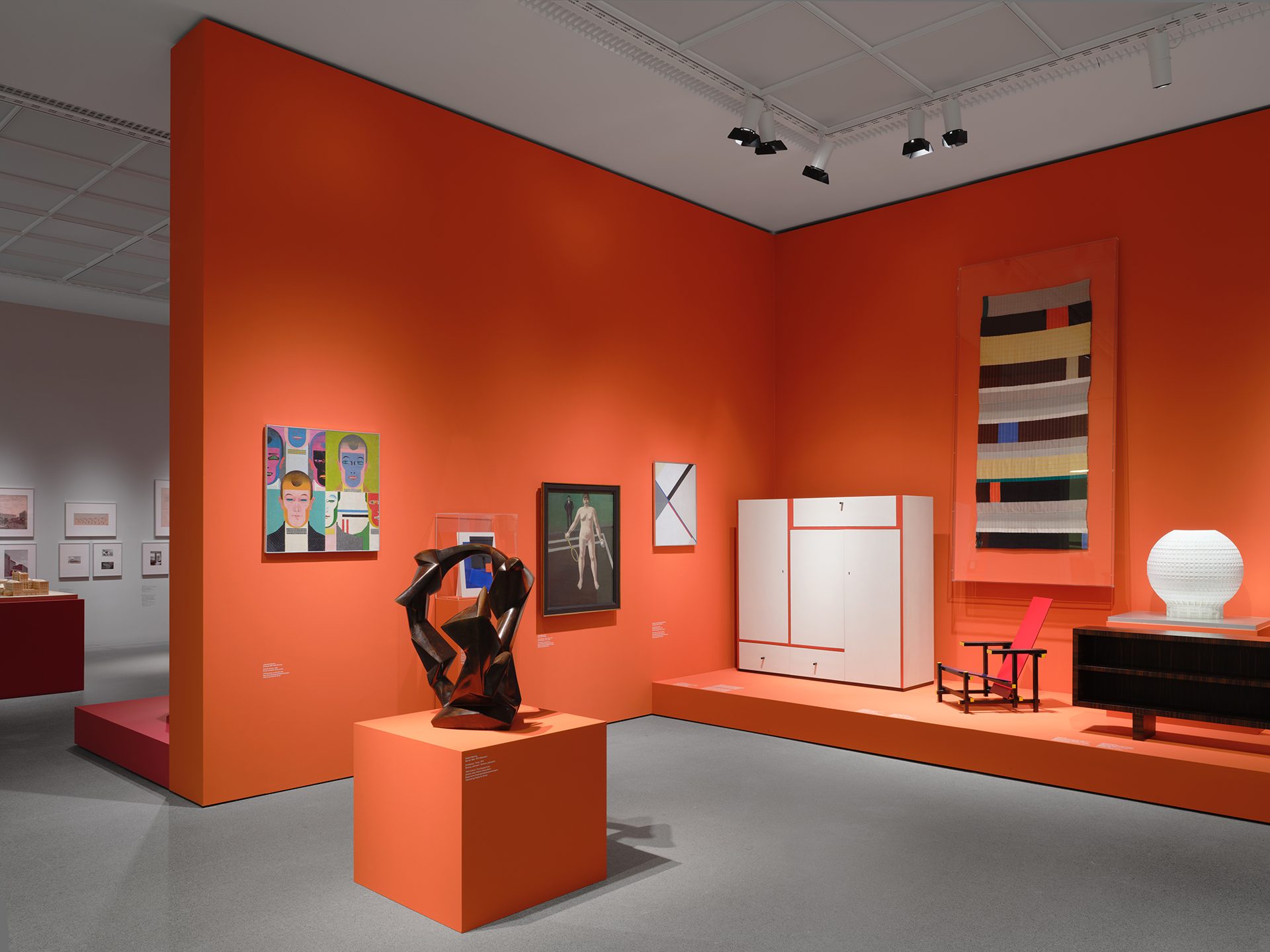 You can see the exhibition installation "4 Museums – 1 Modernism." In the foreground is a sculpture, behind it are furniture and textiles.