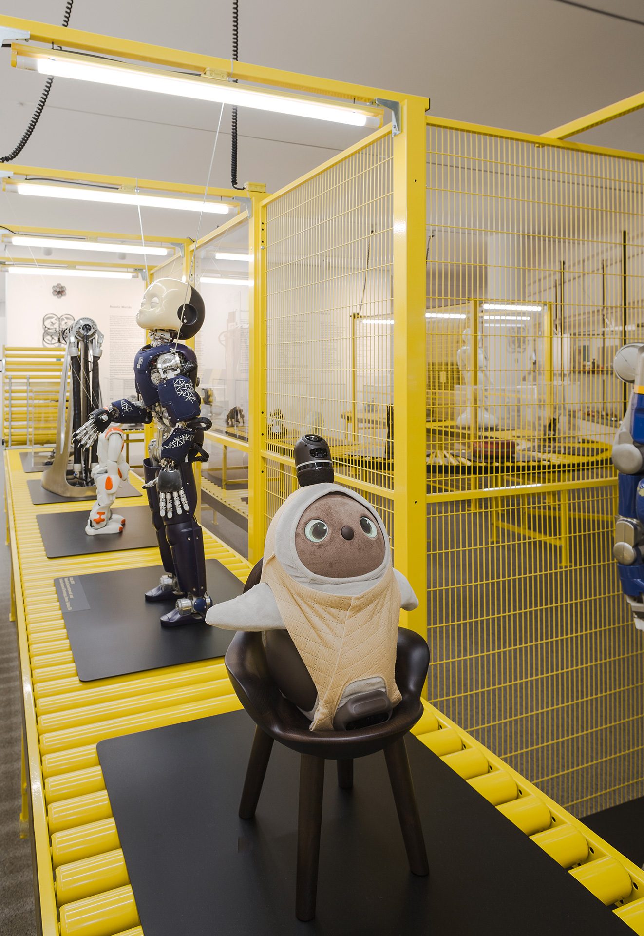 Verschiedene Roboter auf einem glelb lackierten Förderband