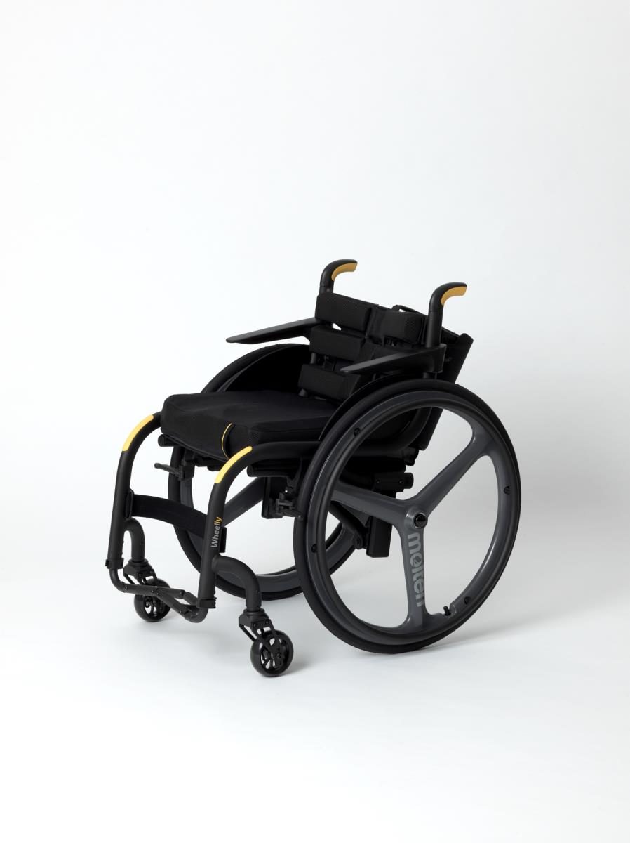 Photo of a black wheelchair with yellow markings on the handles and arch next to the wheels. White background.