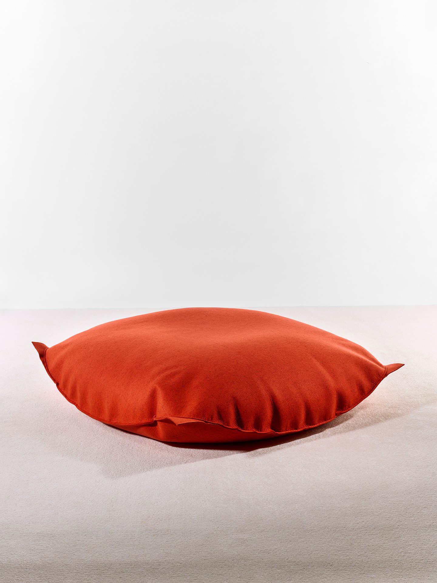 Rotes Sitzkissen aus Wolle und Wollfilz.